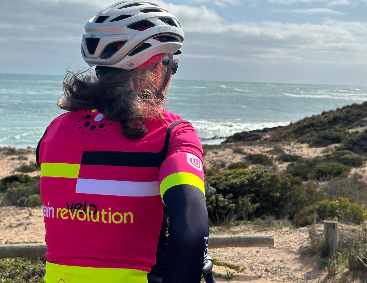 Jess in Pain Revolution bike kit looking out on the ocean